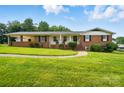 Classic brick home with a well-maintained lawn, inviting porch, and traditional American flag display at 2968 Grace St, Claremont, NC 28610