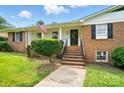 Inviting brick front entrance with neat landscaping, black shutters, and American flag waving above at 2968 Grace St, Claremont, NC 28610