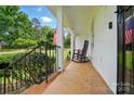 Relaxing front porch view with rocking chair, decorative cushions, and a glimpse of the lush front yard at 2968 Grace St, Claremont, NC 28610