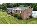 An aerial view of the brick home, showing the expansive yard, pool, and manicured landscaping at 2968 Grace St, Claremont, NC 28610