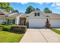 Inviting exterior of townhome with mature landscaping, attached two-car garage, and brick accents at 31415 Royal Tern Ln, Fort Mill, SC 29707
