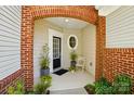 Charming front porch with brick archway and round window, leading to an inviting entryway at 31415 Royal Tern Ln, Fort Mill, SC 29707