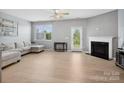 Bright living area featuring modern gray paint, natural light, and a fireplace with glass door to backyard at 3306 Yarmouth Ln, Gastonia, NC 28056
