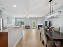 Open-concept space with kitchen island, living, dining areas, wood flooring, and natural light creating an inviting atmosphere at 3306 Yarmouth Ln, Gastonia, NC 28056