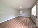 Freshly painted bedroom features clean, plank flooring and bright sunlight from multiple windows at 409 Anne Ave, Waxhaw, NC 28173