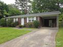 Lovely brick home showcasing a well-kept lawn and attached carport for convenient parking at 409 Anne Ave, Waxhaw, NC 28173