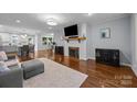 Cozy living room showcasing a fireplace, a wall-mounted TV, hardwood floors, and an open floor plan at 4106 Castlewood Rd, Charlotte, NC 28209