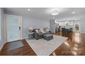 Inviting living room featuring hardwood floors, a gray sofa set with plush pillows, and an open layout to the kitchen at 4106 Castlewood Rd, Charlotte, NC 28209