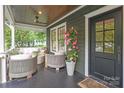 Inviting front porch featuring stylish seating, dark painted floors, and a ceiling fan at 501 E Tremont Ave, Charlotte, NC 28203