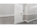 Neutral toned hallway with clean white trim leads to unit's entrance, providing privacy and refined access at 5425 Closeburn Rd # 208, Charlotte, NC 28210