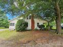 Rear of home with a brick chimney and lush trees at 562 W Wilson Ave, Mooresville, NC 28115