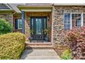 Inviting front door with brick surround, decorative plants, and stylish exterior lighting at 5826 Natoma Rd, Lake Wylie, SC 29710