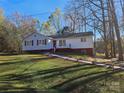 Inviting single-story home with red shutters and a manicured lawn is bathed in natural light at 7154 Woodcock Trl, Stanley, NC 28164