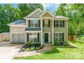 Inviting two-story home with a quaint front yard featuring flowering plants, driveway, and attached garage at 7206 Stoney Place Ct, Charlotte, NC 28262