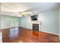 Cozy living room with hardwood floors, a fireplace, neutral walls, and ample natural light at 7206 Stoney Place Ct, Charlotte, NC 28262