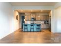 A kitchen features an island with bar seating and stainless steel appliances and wood flooring at 7416 Hartsfield Dr, Lancaster, SC 29720
