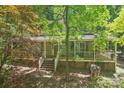 Two-story home featuring a covered front porch and brick foundation nestled among mature trees at 8504 Knollwood Cir, Charlotte, NC 28213