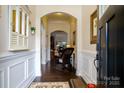 Inviting home foyer featuring hardwood floors, an arched doorway, and decorative wainscoting at 8818 Artesa Mill Ln, Charlotte, NC 28214