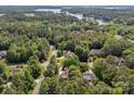 Aerial view of beautiful homes nestled within a dense forest and alongside a tranquil lake at 104 Golden Bell Ct, Mooresville, NC 28117