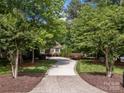View of the long driveway leading up to the home with mature trees and landscaping around the property at 104 Golden Bell Ct, Mooresville, NC 28117