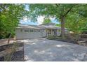 The charming exterior showcasing a well-manicured lawn, a long drive, and a beautifully designed facade with stone accents at 1096 Palmyra Dr, Tega Cay, SC 29708