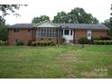 Spacious backyard featuring a screened-in porch and brick exterior at 116 Lanes End Rd, Locust, NC 28097