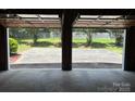 View from inside garage shows concrete floor extending to concrete drive and lawn beyond at 116 Lanes End Rd, Locust, NC 28097