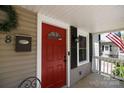 Inviting front porch view showcasing a vibrant red door, exterior lighting, and classic house number at 118 Sunset Dr, Clover, SC 29710