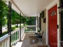 Covered front porch, showcasing comfortable seating and a bright red front door at 118 Sunset Dr, Clover, SC 29710