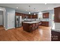 Expansive kitchen features hardwood floors, center island with seating, stainless steel appliances, and lots of storage at 1230 Long Creek Ln, Salisbury, NC 28146