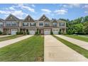 Charming townhomes featuring attached garages, manicured lawns, and stylish exterior finishes at 12408 Savannah Cottage Dr, Charlotte, NC 28273