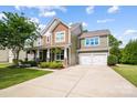 Charming two-story home with a well-manicured lawn, covered porch, and attached two-car garage at 132 Flora Vista Dr, Mooresville, NC 28117