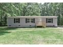 Charming single-story home with gray siding, black shutters, new front deck and lush green lawn at 1380 St. Johns Church Rd, Concord, NC 28025