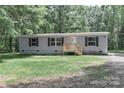 Well-maintained single-story home featuring gray siding, black shutters, a small wood porch, and green lawn at 1380 St. Johns Church Rd, Concord, NC 28025