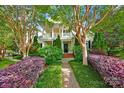 Charming two-story home featuring a welcoming porch, brick pathway, and lush landscaping, offering curb appeal at 14505 Sunset Walk Ln, Huntersville, NC 28078