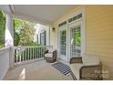 Inviting covered porch features comfortable seating, creating a relaxing outdoor space at 14505 Sunset Walk Ln, Huntersville, NC 28078