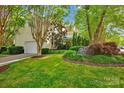 Well-maintained home featuring an attached garage, green lawn, and mature trees adding beauty at 14505 Sunset Walk Ln, Huntersville, NC 28078