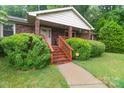Inviting brick home entrance with covered porch and manicured greenery along the walkway at 151 Deja Ln, Cleveland, NC 27013