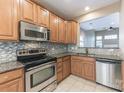 Well-lit kitchen featuring wooden cabinets, stainless steel appliances, and granite countertops at 165 N Arcadian Way, Mooresville, NC 28117