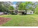 Well-maintained home with lush green lawn and mature trees, featuring an attached garage and covered porch at 1737 Hwy 109 N Hwy, Troy, NC 27371
