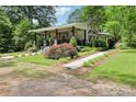 Inviting home with a covered front porch, stone pillar accents, and meticulously landscaped front yard at 1737 Hwy 109 N Hwy, Troy, NC 27371