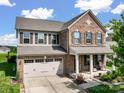 Charming two-story brick home featuring a two-car garage, front porch, and manicured landscaping at 2178 Stone Pile Sw Dr, Concord, NC 28025