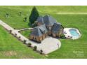 Expansive aerial view of a home with a private pool and a long driveway on a well-manicured lawn at 270 Sandhills Ct, Mooresville, NC 28115