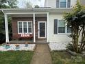 Charming home featuring a cozy front porch, brick accents, and well-maintained landscaping at 327 Wilkes Place Dr, Fort Mill, SC 29715