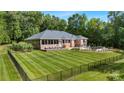 Expansive backyard with lush lawn and a brick home featuring a sunroom and outdoor entertainment space at 408 Emerald Bay Dr, Salisbury, NC 28146