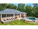 Beautiful backyard of brick home featuring a pool, patio, and well-manicured lawn at 408 Emerald Bay Dr, Salisbury, NC 28146