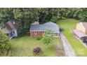 Birds-eye view showcases this brick ranch home, its detached carport, and mature shady trees at 4915 Galax Dr, Charlotte, NC 28213