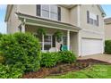 Close-up view of the front of this two-story home featuring manicured landscaping and a teal front door at 507 Galesburg Dr, Monroe, NC 28110