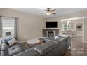 Inviting living room featuring a fireplace, ceiling fan and a comfortable leather sectional sofa at 507 Galesburg Dr, Monroe, NC 28110