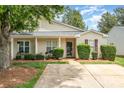 Charming single-story home features a welcoming front porch, manicured landscaping, and a well-maintained lawn at 5402 Harris Cove Dr, Charlotte, NC 28269